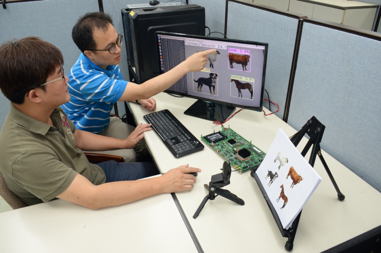 ETRI 김주엽 선임연구원(왼쪽)과 조민형 책임연구원이 시각지능 칩을 통해 사물인지 기술을 실험하고 있다. /사진=ETRI