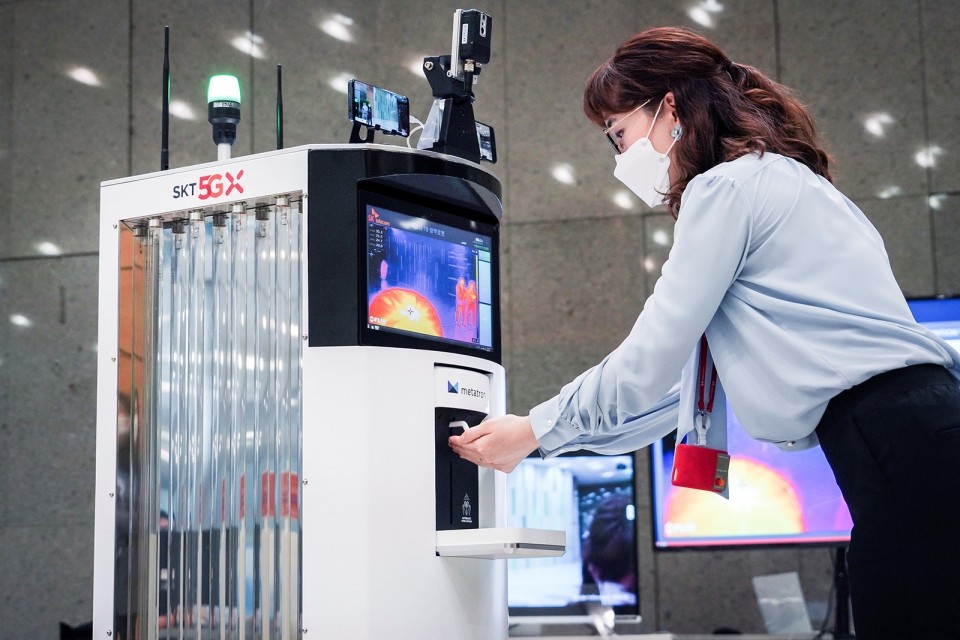 코로나19방역로봇이 방문객에게 손 소독제를 제공하고 있는 모습 (사진=SK텔레콤)