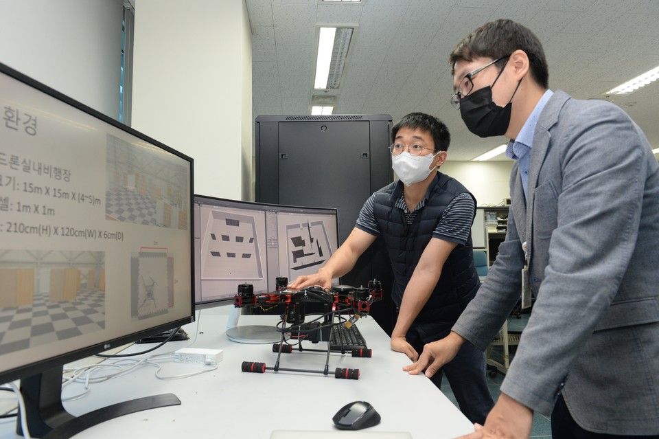 ETRI 연구진이 개발한 재난 현장 드론용 탐색지능 자율무인정찰 시스템을 점검하고 있는 모습. (왼쪽부터) 장수영 선임연구원, 전지훈 연구원 (사진=ETRI)