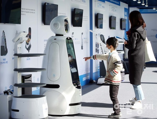 판교 자율주행 광장에서 관람객이 참가기업들의 자율주행 AI로봇을 살펴보고 있다. (사진=킨텍스)