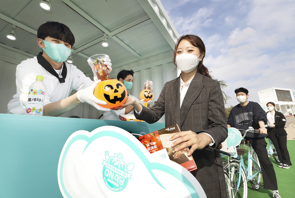 고객이 ‘2020 ON식당 in 서울’의 바이크 스루 코스를 통해 음식을 픽업하고 있다. (사진=KT)