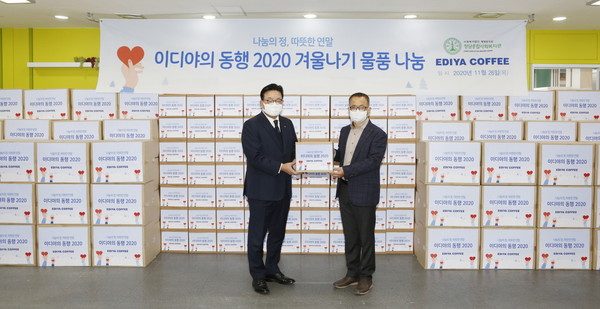 11월 26일 서울 금천구 청담종합사회복지관에서 진행된 '이디야의 동행' 기부행사에서 이디야커피 경영지원부문 김남엽 부사장(좌)과 청담종합사회복지관 유영학 관장(우)이 포즈를 취하고 있다. (제공=이디야커피)