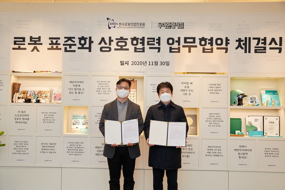 우아한형제들 로봇사업실 김요섭 이사(좌측)와 한국로봇산업진흥원 우종운 인증평가사업단장(우측)이 지난달 30일 서울 송파구 우아한형제들 본사에서 ‘로봇 표준화 상호협력 업무협약(MOU)’을 체결하고 기념촬영을 하고 있다. (사진=우아한형제들)