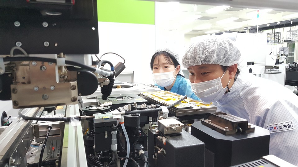 ETRI 연구진이 중소기업 연구원과 함께 고속 광원소자의 본딩 공정을 진행하고 있다. (사진=ETRI)