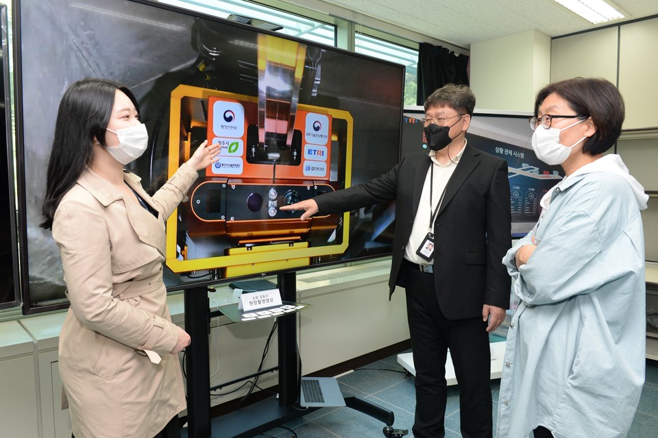 ETRI 연구진이 청주 오창 공동구에서 AI 레일 로봇 관련 설명을 하고 있는 모습. (왼쪽부터) KI 김은솔 연구원, ETRI 정우석 센터장, ETRI, 이미숙 책임연구원 (제공=ETRI)