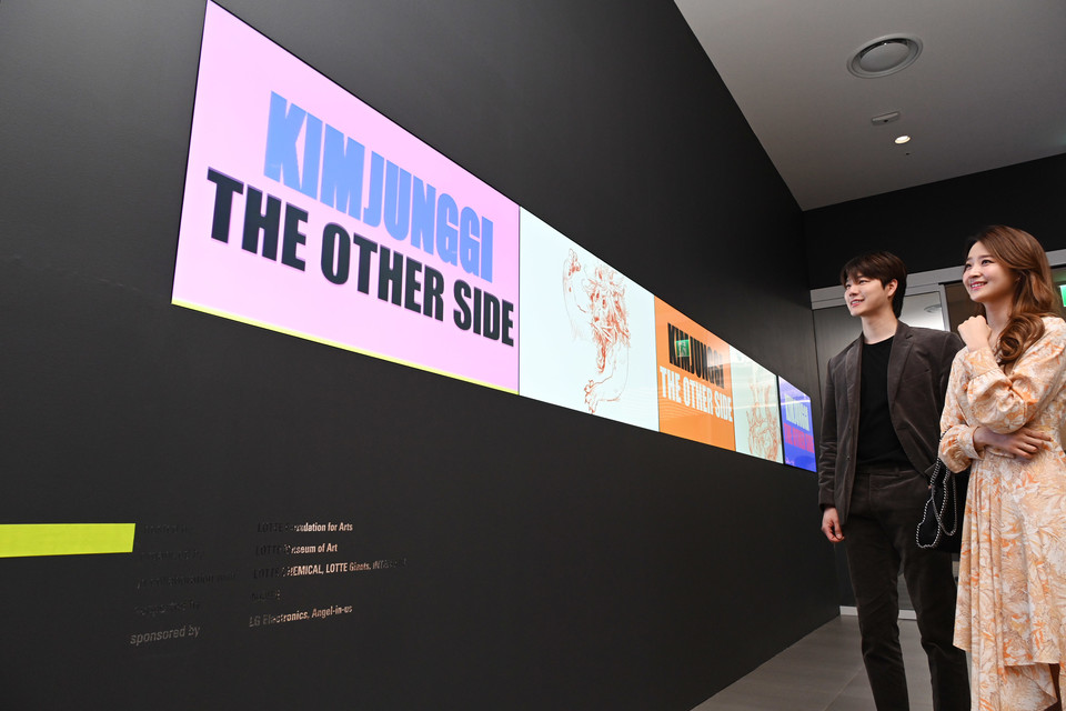 모델들이 LG 디지털 사이니지를 이어붙여 만든 가로 6미터 길이 비디오월을 통해 작품을 감상하고 있다. (제공=LG전자)