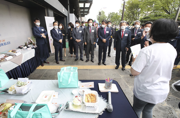 KT 구현모 대표(왼쪽 두 번째) 등 광화문 원팀 소속 임직원들이 나눠정(情) 나눔장터에서 밀키트 상품에 대한 소개를 듣고 있다. (제공=KT)