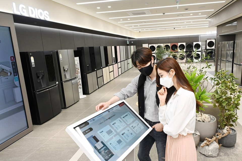 LG전자가 26일부터 국내 가전회사 가운데 처음으로 무인매장을 운영한다. 모델들이 무인매장에서 키오스크를 이용해 제품 정보를 확인하고 있다. (제공=LG전자)