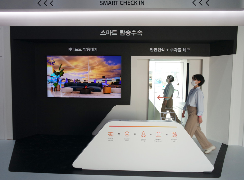 한화시스템 기업관을 찾은 관람객이 수속장을 걷기만 해도 신원확인과 수하물 검색이 완료되는 스마트 탑승 수속 과정을 경험해보고 있다. (제공=한화시스템)