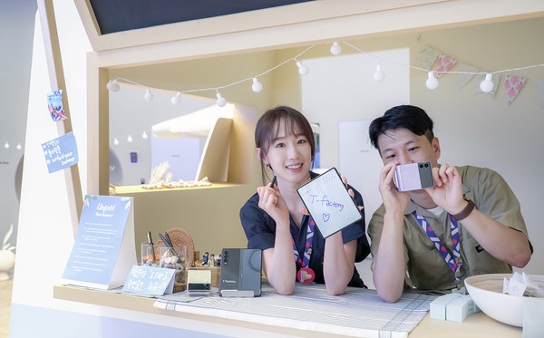 SK텔레콤 직원들이 홍대 ICT멀티플렉스 T팩토리에 설치된 폴더블 체험존을 소개하는 모습 (제공=SK텔레콤)