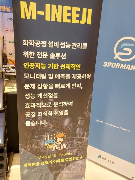 전시장에서 AI기반 공정 예측과 최적화 솔루션을 홍보하는 안내 배너.