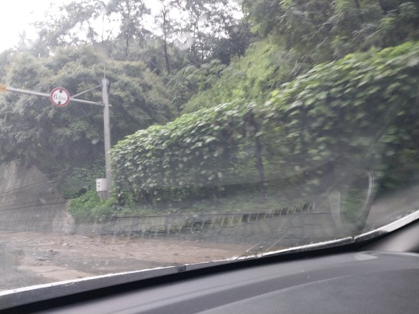 지난 9일 산사태로 인해 경기도 외곽의 한 도로변에 토사와 함께 쏟아진 물이 흘러넘치고 있다. 사진은 운전자가 자동차 안에서 스마트폰으로 급히 찍은 것이다.