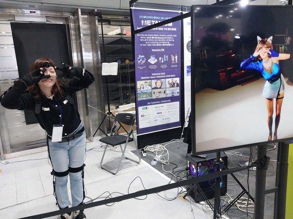 (주)메타브릭의 직원이 자사 메타버스 SW플랫폼인 '메타니움'을 홍보하기 위해 몸소 춤동작을 펼쳐보이며 시연하고 있다.