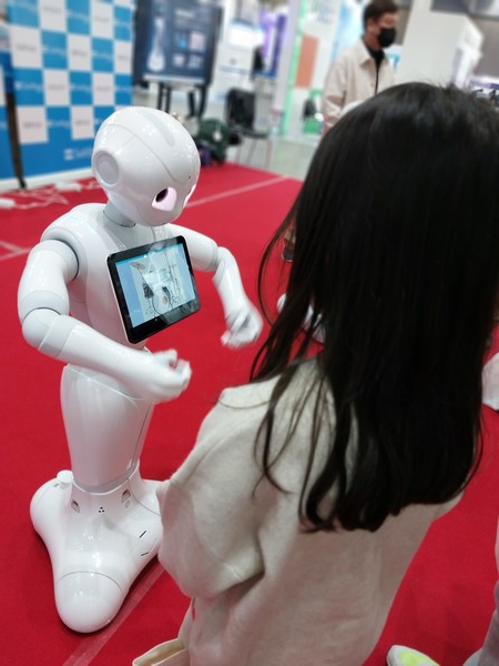 한 어린이가 호기심을 갖고 매장 서빙 로봇을 살피고 있다.