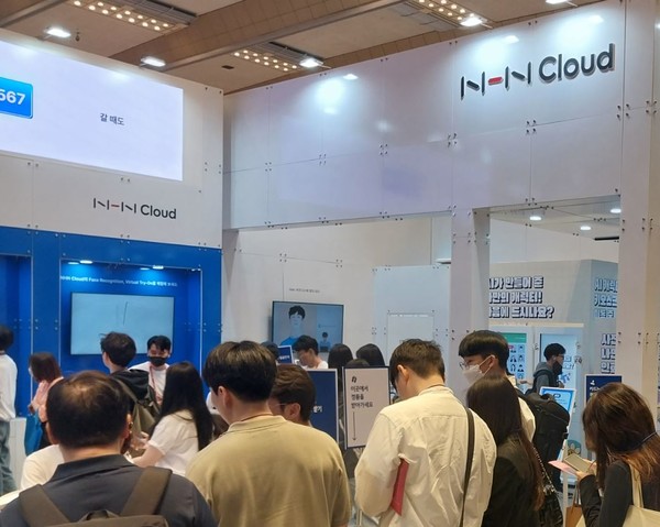 'AI엑스포 2023'에 전시된 네이버 클라우드 홍보부스를 둘러보는 관람객들.
