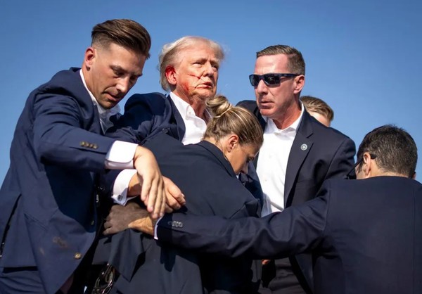 트럼프 전 미국 대통령이 유세 집회에서 피격 직후 경호원들에 둘러싸여 있다. (사진=뉴욕타임스)
