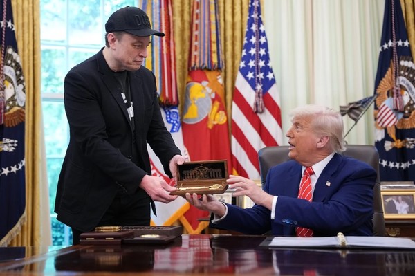 지난 30일 'DOGE' 수장에서 물러나는 머스크를 위해 마련한 기자회견 자리에서 트럼프 대통령이 작별인사차 기념패를 건네고 있다. 그러나 트럼프는 “머스크는 여전히 떠나지 않고, 왔다갔다할 것”이라고 해 언론으로부터 ‘기이한 기자회견’이란 평을 듣기도 했다.(사진=게티 이미지)