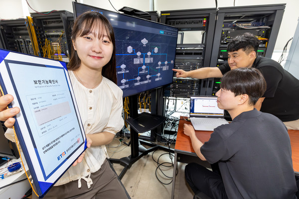 KT와 코위버 직원이 양자키분배 기술 적용 장비를 점검하며 보안 인증서를 소개하고 있다.(사진:KT)