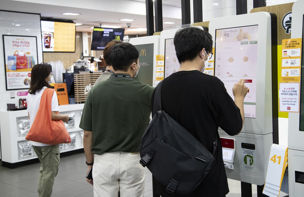 사람들이 키오스크로 주문하는 모습.(사진:로이터 라이센스)